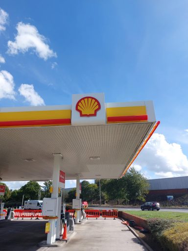 Shell petrol station with a prominent logo against a blue sky.